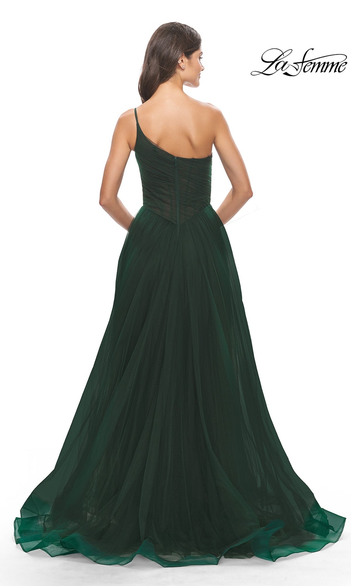 A woman in a dark green One-Shoulder Sheer-Bodice Prom Ball Gown 31069 stands facing away, showcasing the gown’s elegant back details against a white background.